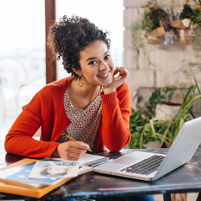 Female smiling as she is writing her plans