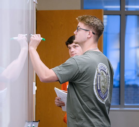 Two students at whiteboard