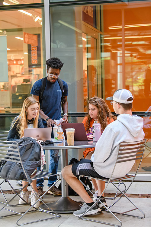 Group of students at table with laptops