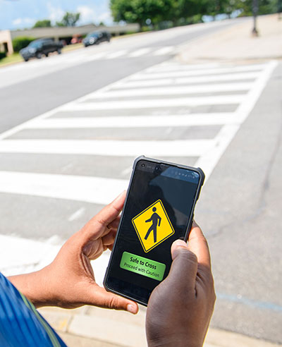 Phone with safe to cross message at crosswalk