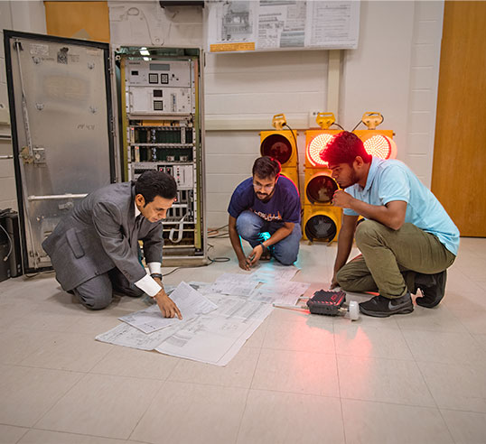 Chowdhury and graduate researchers looking at plan blueprint