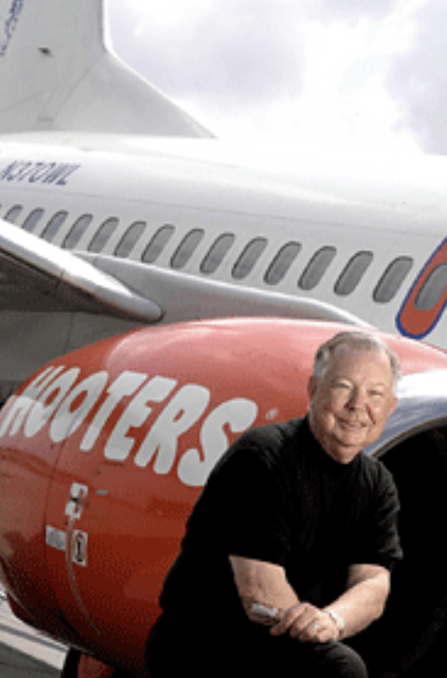 Robert H. Brooks poses beside an airplane