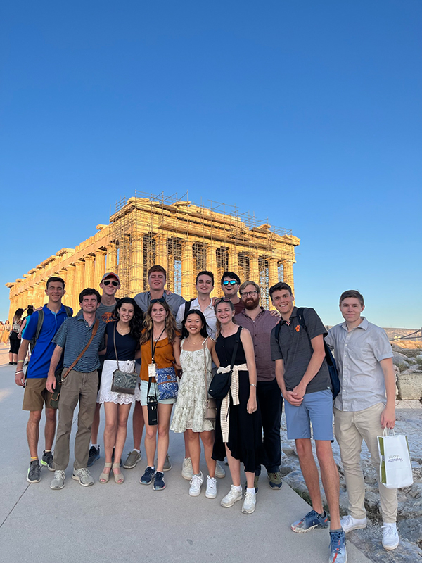 Reci=onstruction on ruins in Greece with a group of students in front of it.