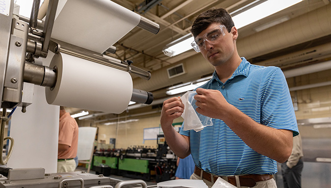 student laminating an object