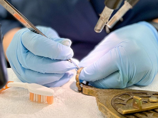 Up close of work restoring metal piece