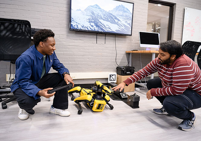 Two students from lab using Spot the robot.