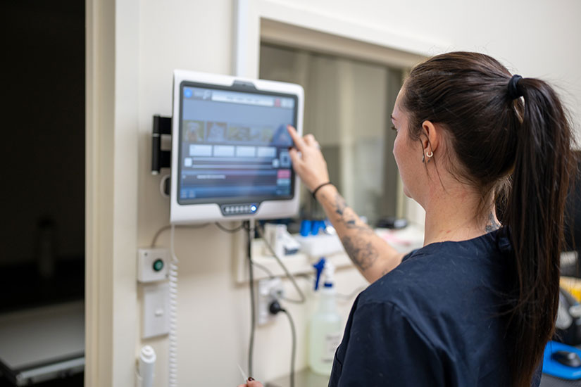 Woman using health monitor in medical office