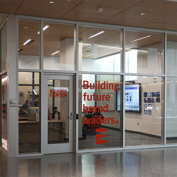Erwin Center entrance featuring a glass facade with the text "Building future brand leaders."