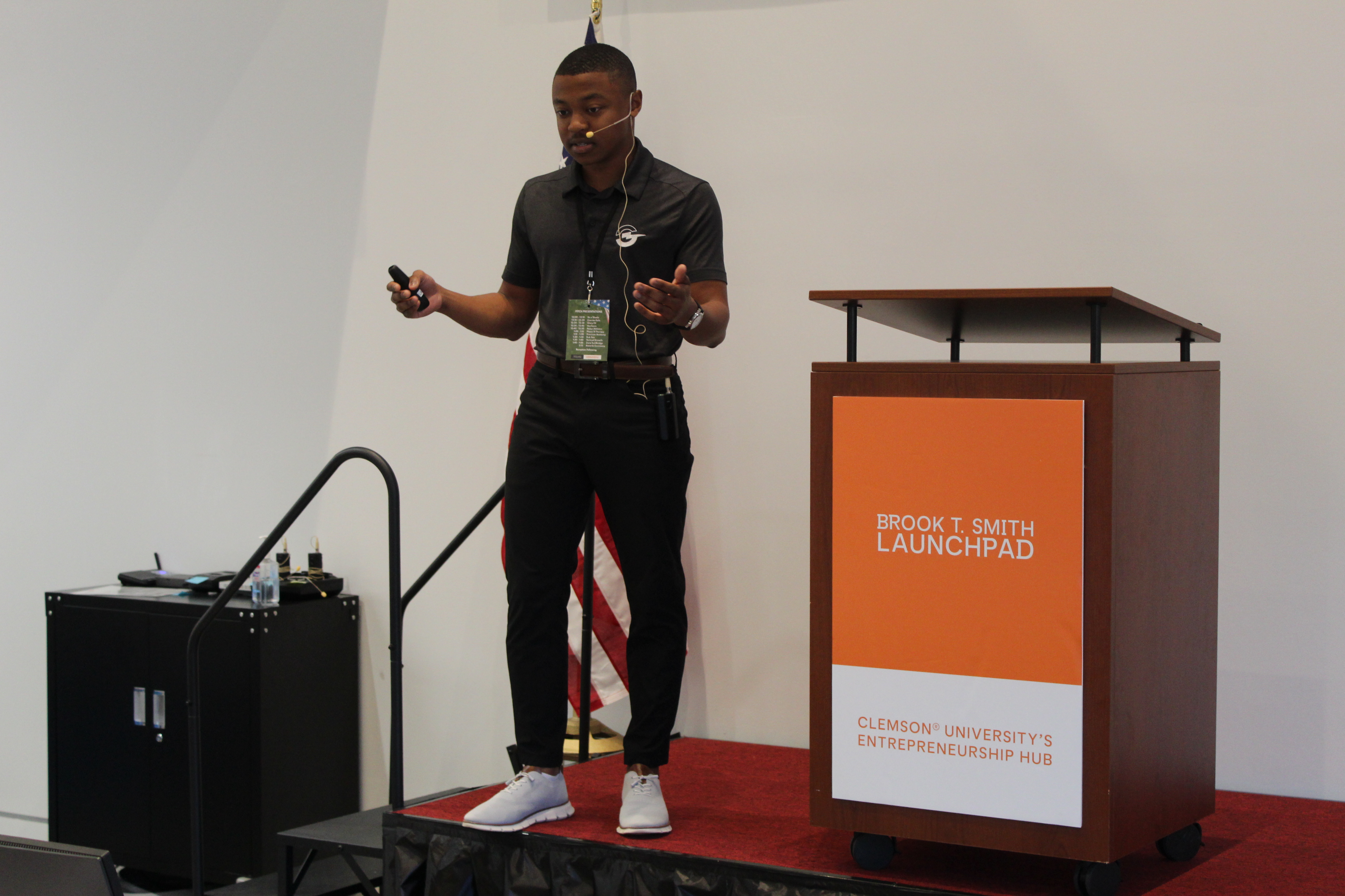 Speaker wearing a headset presents on stage beside a podium labeled “Brook T. Smith Launchpad” at Clemson University’s entrepreneurship hub.