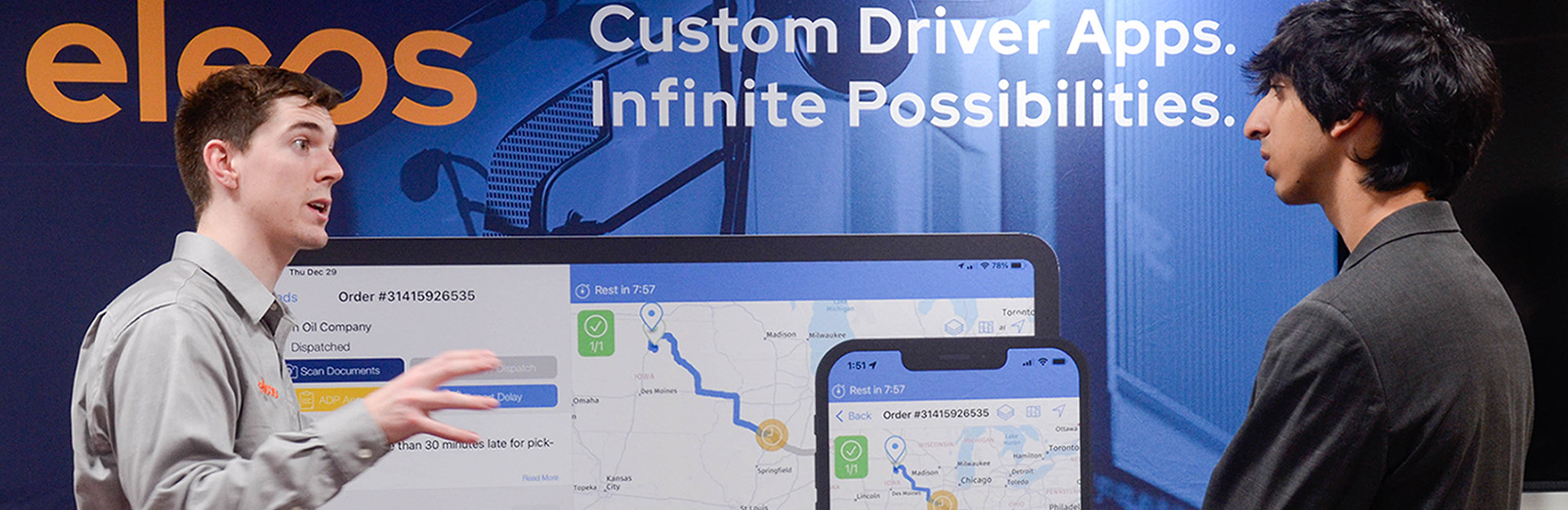 Two people talking in front of a screen