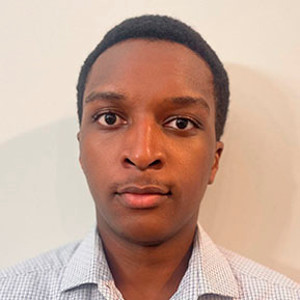 Professional headshot of a young man with short hair, wearing a collared shirt.