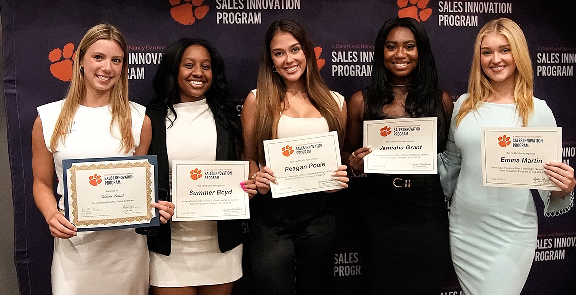 Five females students holding certificates.