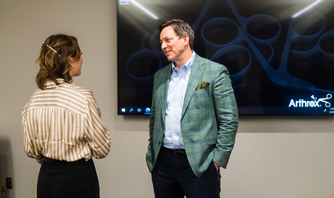 Man and woman talking in front of TV screen