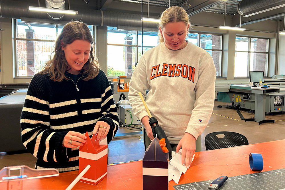 Two female students working with machine