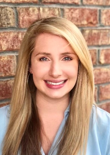 Photo of Taylor Haynes with blond hair and light blue shirt.