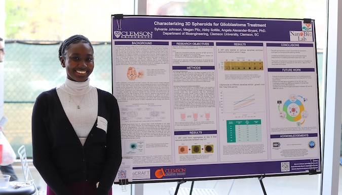 Student posing in front of a poster