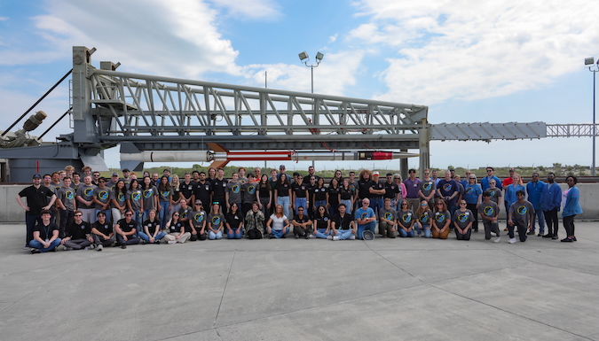 Students, engineers and staff in front of the rocket launch mount at Wallops Flight Facility