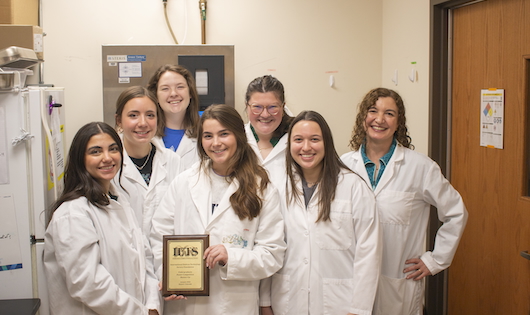 Carolina Elgaressta, Logan Thomason, Hannah Culler, Christian Wilhelm, Katie Kirkman, Izabella Zaraca and Dr. Celina Checura pose with their award plaque