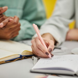 A woman writes on a document.