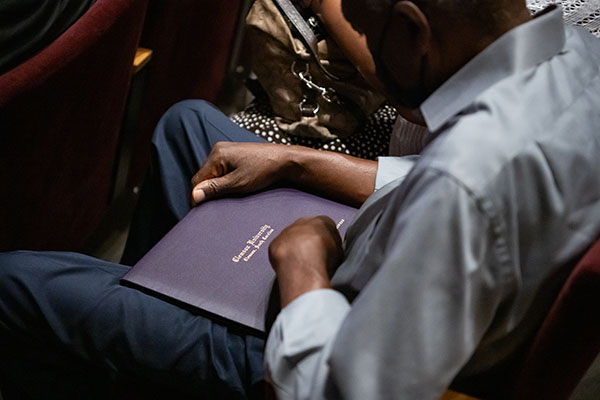 Student holding their diploma cover