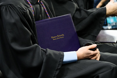 Student holding their diploma cover
