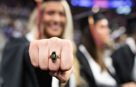 Close up view of the Clemson Ring with the owner face blurry from being out of focus.