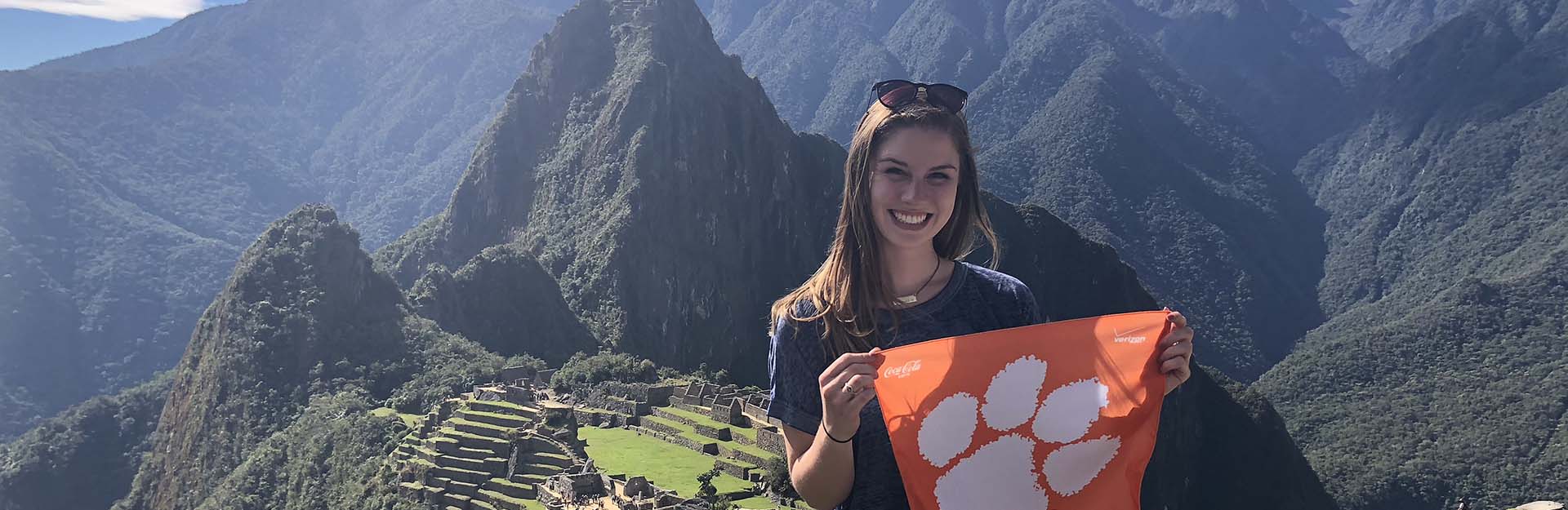 Student holding a Tiger Rag on a mountainside
