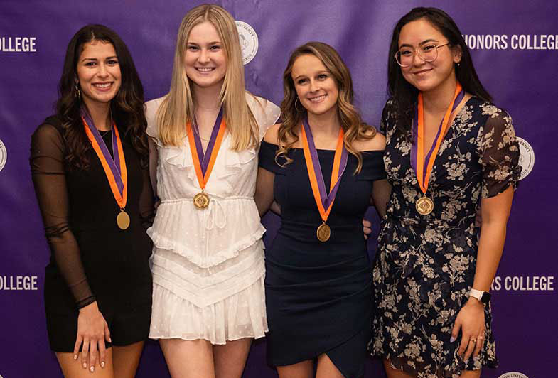 Four smiling Honors students at the awards ceremony