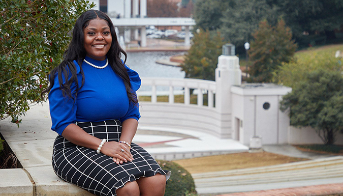 Amoira Rush sitting by the reflection pond on campus