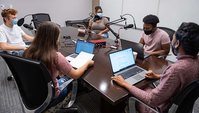 Students recording a podcast in a classroom.