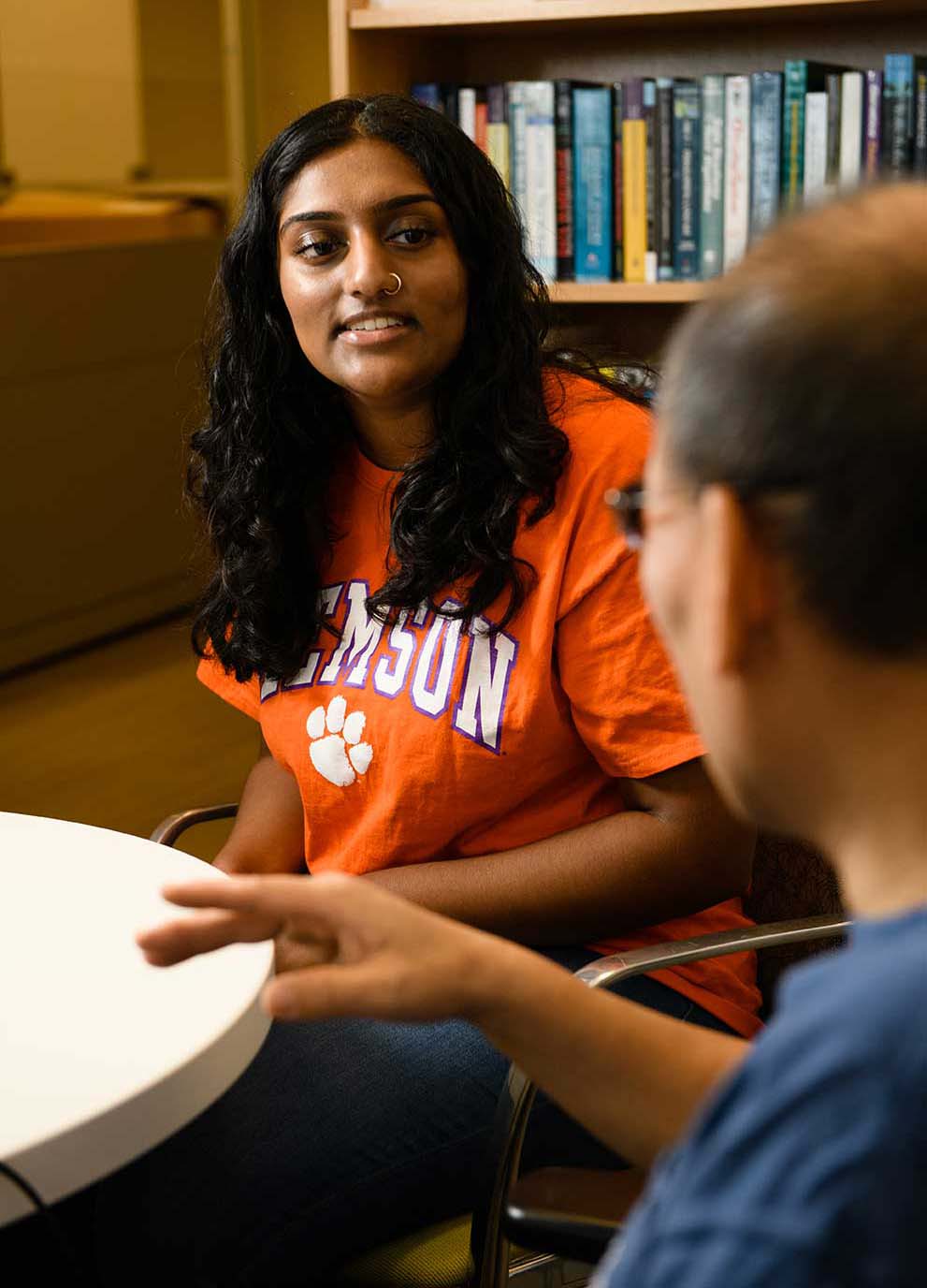 A student in conversation with a professor