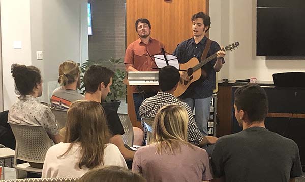 Two students performing for a room full of Honors students in the Great Hall