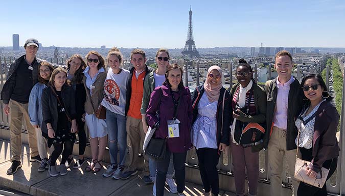 a group of students posing in front of the Eiffel Tower