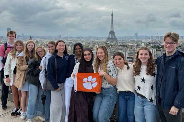 A group of students posing with a Tiger Rag with the Eiffel Tower in the background 