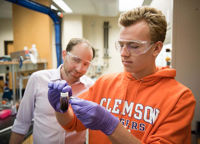 Dr. Mefford watching a student perform an experiment.