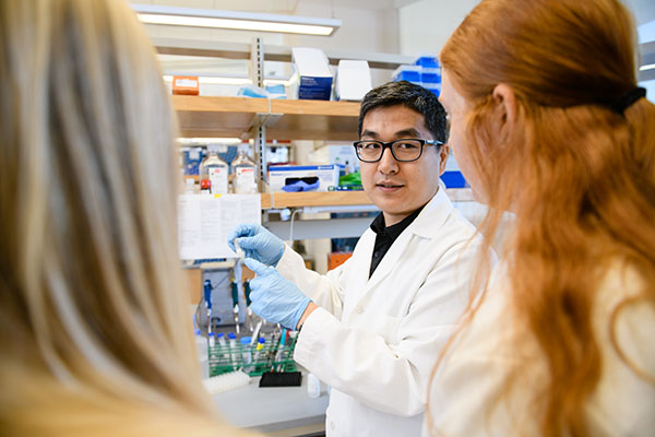 A professor talking to his students in a lab