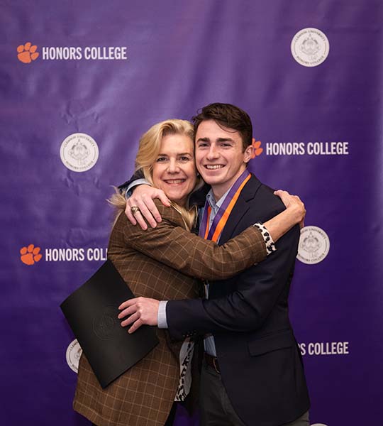 Dean Hossfeld hugging an Honors graduate
