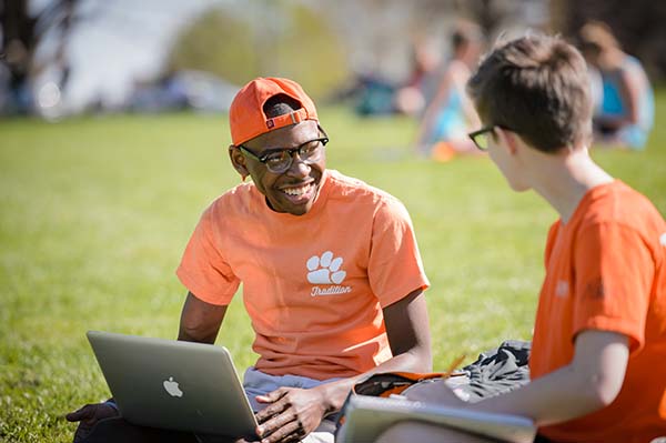 Two students sitting on Bowman Field