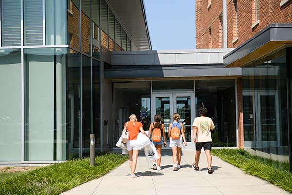 A family walking towards the Honors College doors. 