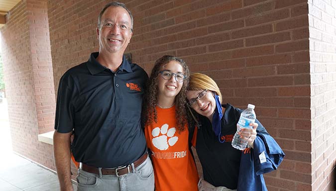 Parents posing with their daughter outside the Honors Center