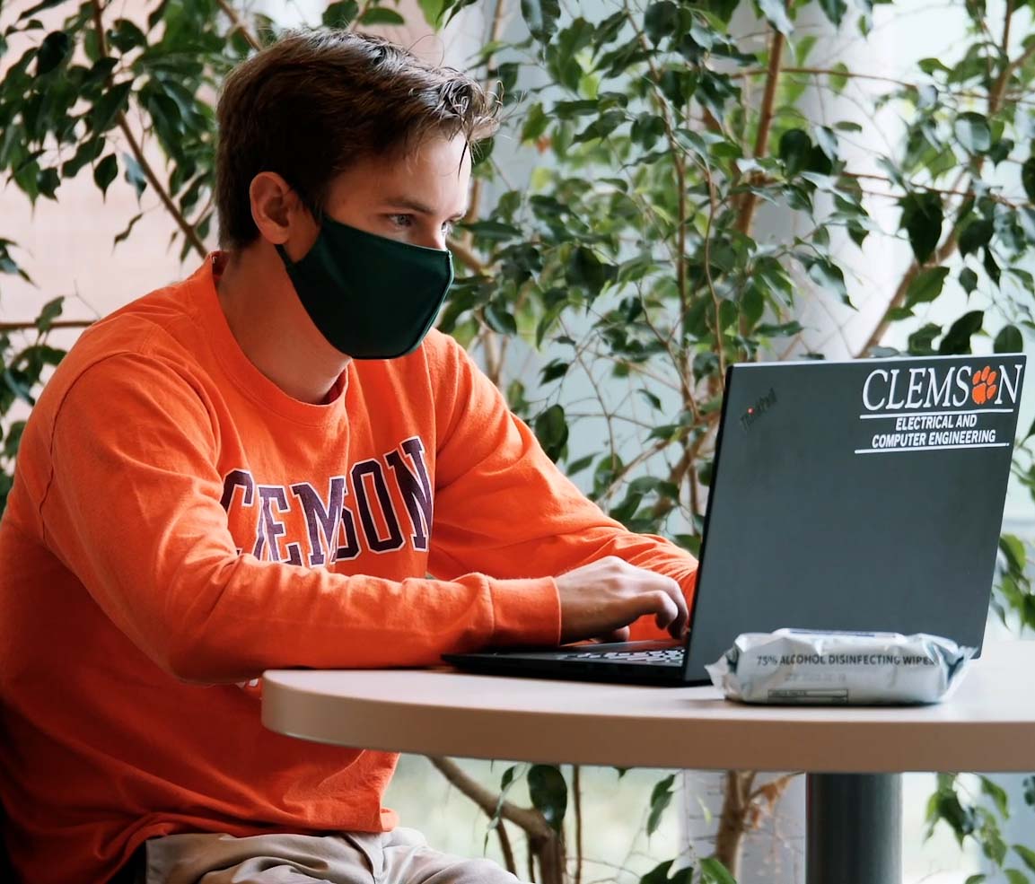 Student wearing a mask and working on a laptop