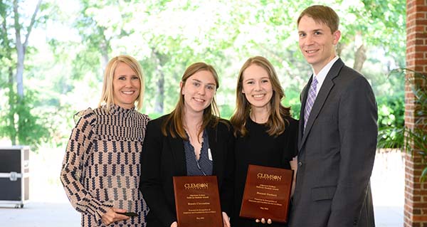 The three Clemson Honors Advisors sitting on the steps outside of the Honors Center.