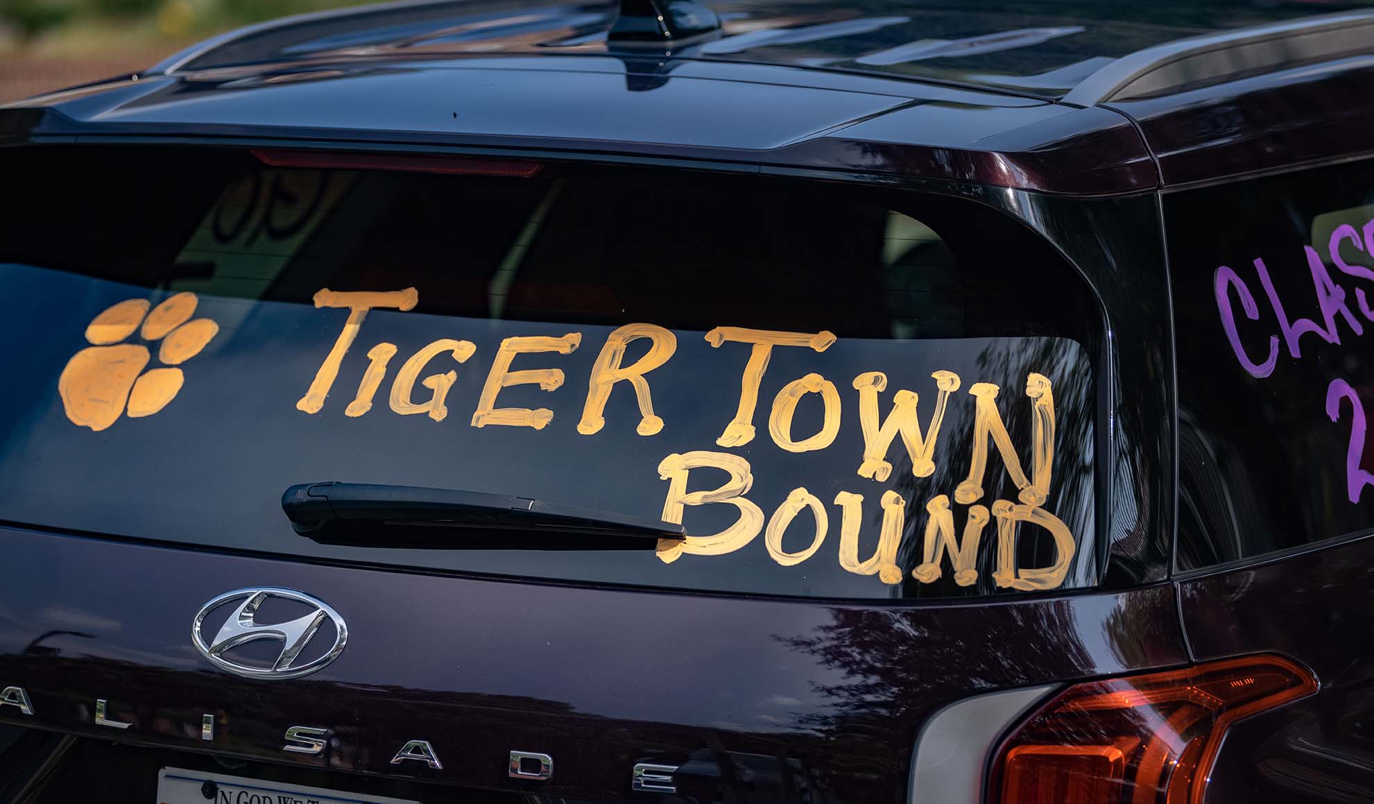 A car's back window with TigerTown Bound painted on it.