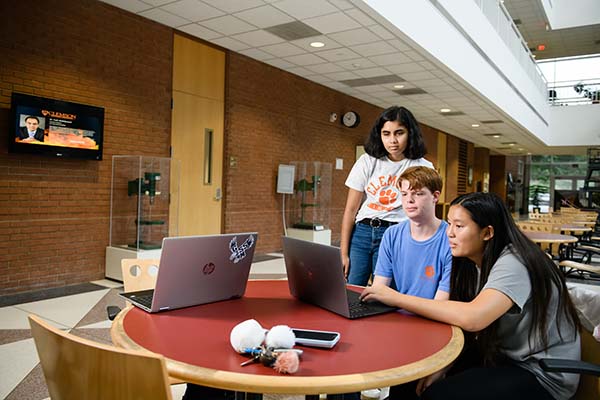 EUREKA! students looking at a laptop screen.
