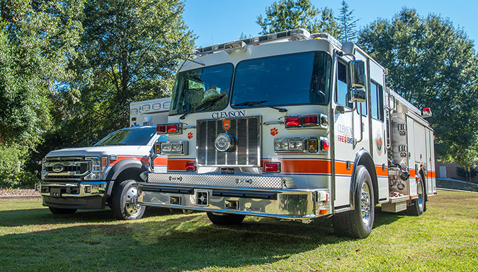 A Clemson Fire truck and ambulance in a grassy field on the University's main campus.