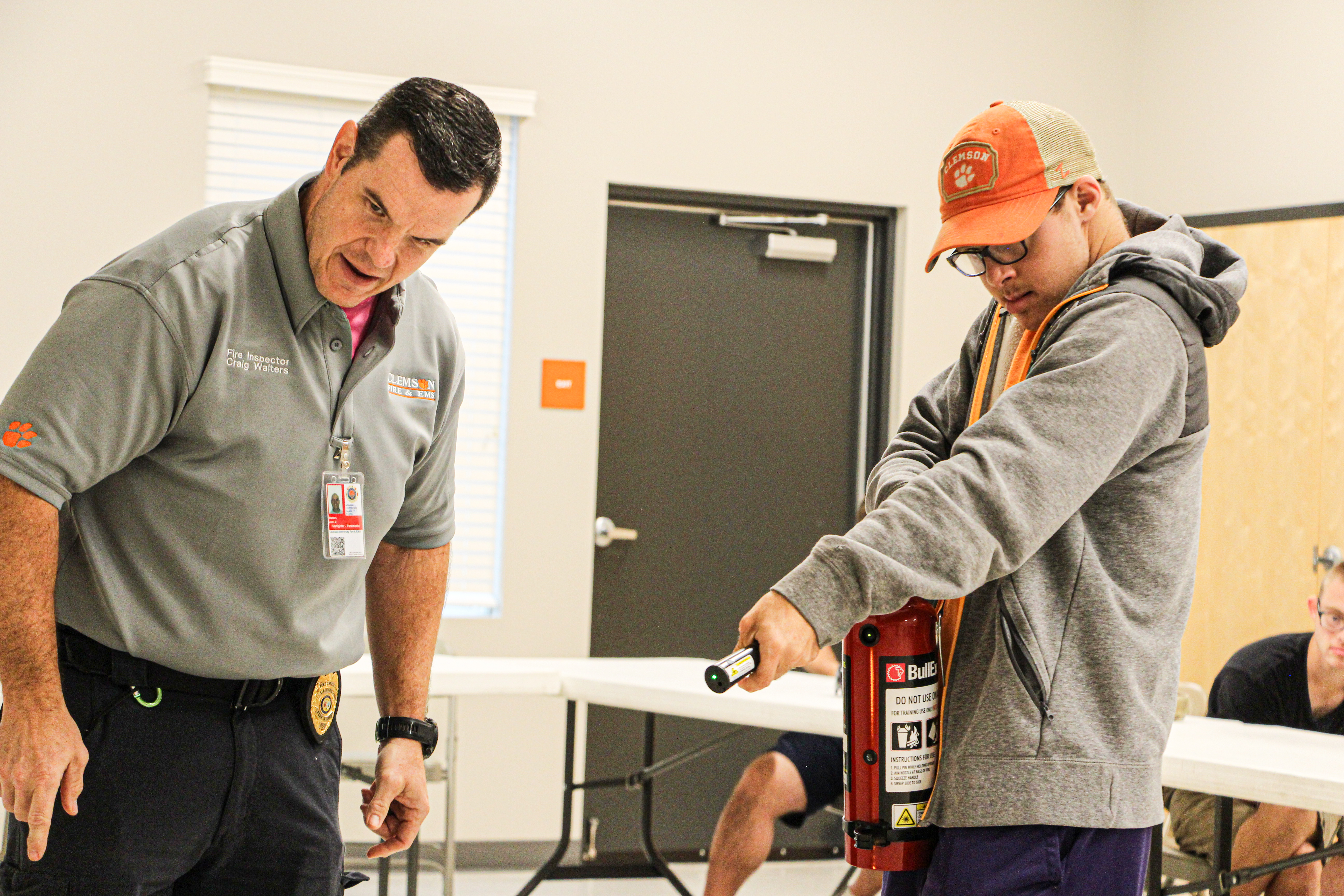 A Clemson student learns how to use a fire extinguisher from an instructor.