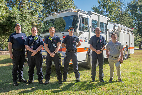 Group of firefighters standing in front of a CUFD fire engine.