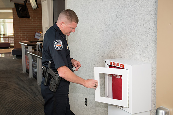 Lt. Chris Harrington opens the Tramedic® wall mounted cabinet displaying the kit.