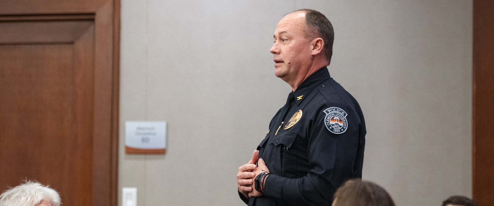 A man in a police uniform standing and speaking.