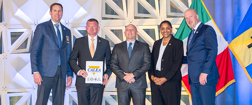 Members of CUPD stand alongside members of CALEA staff in front of a white backdrop.